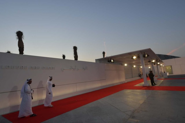 Emirati men stand at the entrance to the Louvre Abu Dhabi prior to the inauguration of the museum on November 8, 2017. More than a decade in the making, the Louvre Abu Dhabi is opening its doors bringing the famed name to the Arab world for the first time. / AFP PHOTO / Giuseppe CACACE