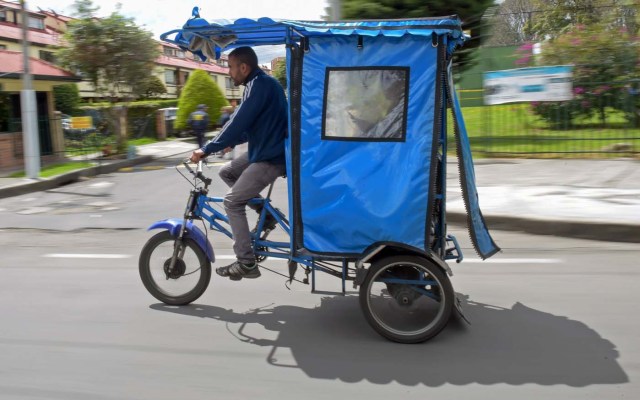 Venezuelan national Gregory Pacheco, 29, works as a "bicitaxi" (pedicab) driver in Bogota, on November 8, 2017. Up to October 2017 there were 470,000 Venezuelans in Colombia, who left their country to escape the hardship and violence of its economic and political crisis. / AFP PHOTO / Raul Arboleda / TO GO WITH AFP STORY by Daniela QUINTERO and Santiago TORRADO