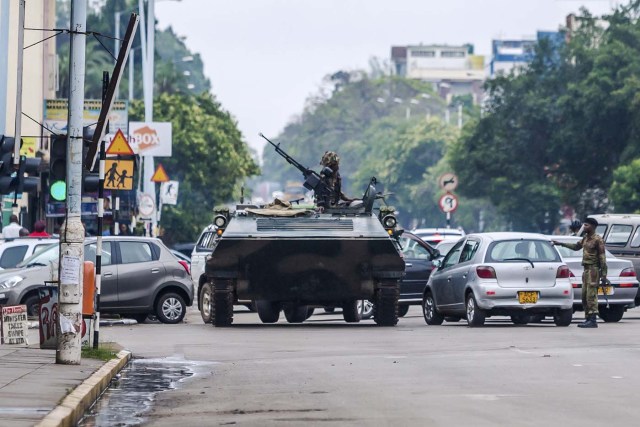 An armoured personnel carrier stations by an intersection as Zimbabwean soldiers regulate traffic in Harare on November 15, 2017. Zimbabwe's military appeared to be in control of the country on November 15 as generals denied staging a coup but used state television to vow to target "criminals" close to President Mugabe. / AFP PHOTO / -