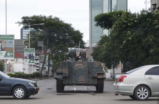 Zimbabwean soldiers stand by an intersection as they regulate civilian traffic in Harare on November 15, 2017. Zimbabwe's military appeared to be in control of the country on November 15 as generals denied staging a coup but used state television to vow to target "criminals" close to President Mugabe. / AFP PHOTO / -