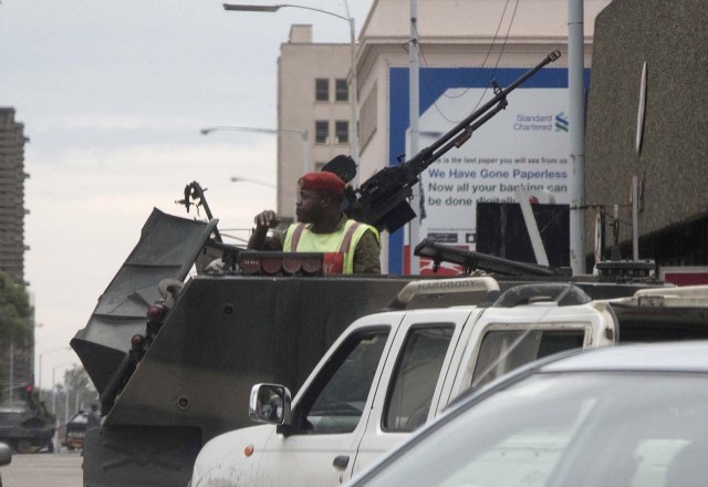 Zimbabwean soldiers stand by an intersection as they regulate civilian traffic in Harare on November 15, 2017. Zimbabwe's military appeared to be in control of the country on November 15 as generals denied staging a coup but used state television to vow to target "criminals" close to President Mugabe. / AFP PHOTO / -