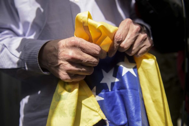 The mayor of Caracas, Antonio Ledezma -who had been arrested and jailed in February 2015 after being accused of plotting to overthrow the president- holds a Venezuelan flag at El Dorado International Airport in Bogota, Colombia, on November 17, 2017, before embarking to Spain after escaping house arrest in the Venezuelan capital. Ledezma, who was under house arrest following surgery, managed to escape and "entered Colombian territory by land, over the Simon Bolivar international bridge" Colombia's migration department said. / AFP PHOTO / Raul Arboleda