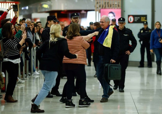 The mayor of Caracas, Antonio Ledezma (C) is greet by family members upon his arrival to the Barajas Airport on November 18, 2017 in Madrid. Ledezma arrived from Bogota to Spain on November 18 after escaping house arrest in the Venezuelan capital, after having been accused of conspiracy against the government of Nicolas Maduro. / AFP PHOTO / OSCAR DEL POZO