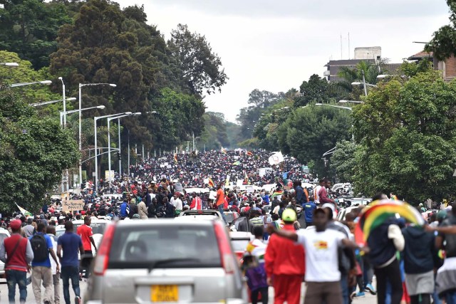 People march towards the State House during a demonstration demanding the resignation of Zimbabwe's president on November 18, 2017 in Harare. Zimbabwe was set for more political turmoil November 18 with protests planned as veterans of the independence war, activists and ruling party leaders called publicly for President Robert Mugabe to be forced from office. / AFP PHOTO / -