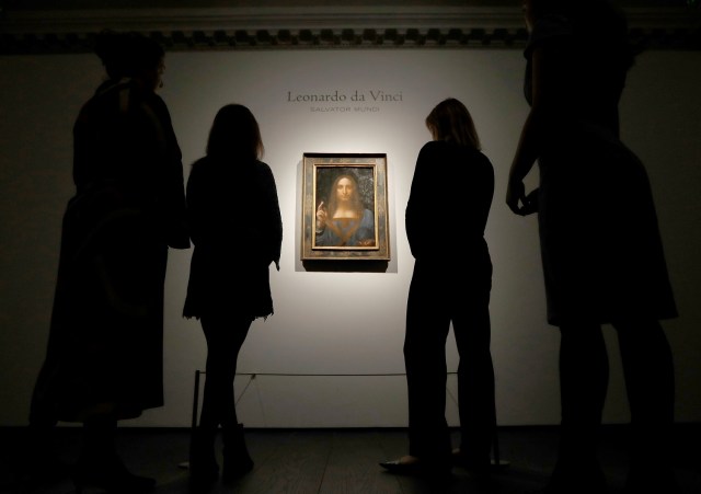 Miembros del personal de Christie posan para fotos junto a la pintura "Salvator Mundi" de Leonardo da Vinci, que será subastada por Christie's en Nueva York en noviembre, en Londres, Gran Bretaña, el 24 de octubre de 2017. REUTERS / Peter Nicholls NO RESALES. SIN ARCHIVOS