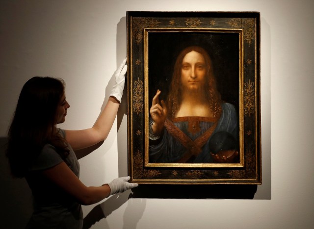 Miembros del personal de Christie posan para fotos junto a la pintura "Salvator Mundi" de Leonardo da Vinci, que será subastada por Christie's en Nueva York en noviembre, en Londres, Gran Bretaña, el 24 de octubre de 2017. REUTERS / Peter Nicholls NO RESALES. SIN ARCHIVOS