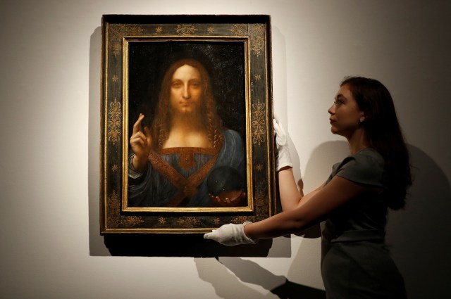 Miembros del personal de Christie posan para fotos junto a la pintura "Salvator Mundi" de Leonardo da Vinci, que será subastada por Christie's en Nueva York en noviembre, en Londres, Gran Bretaña, el 24 de octubre de 2017. REUTERS / Peter Nicholls NO RESALES. SIN ARCHIVOS