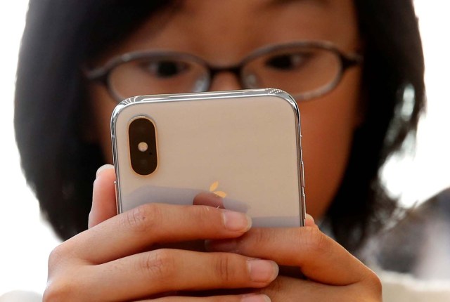 A customer looks at Apple's new iPhone X after it goes on sale at the Apple Store in Tokyo's Omotesando shopping district, Japan, November 3, 2017.REUTERS/Toru Hanai