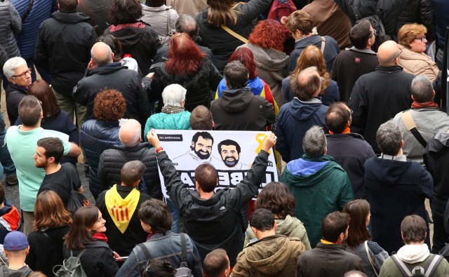 A protester holds a banner depicting the jailed leaders of Catalan pro-independence movements ANC (Catalan National Assembly) and Omnium Cutural, Jordi Sanchez and Jordi Cuixart, as he gathers in Sant Jaume square at a demonstration during a partial regional strike in Barcelona, Spain, November 8, 2017. REUTERS/Albert Gea