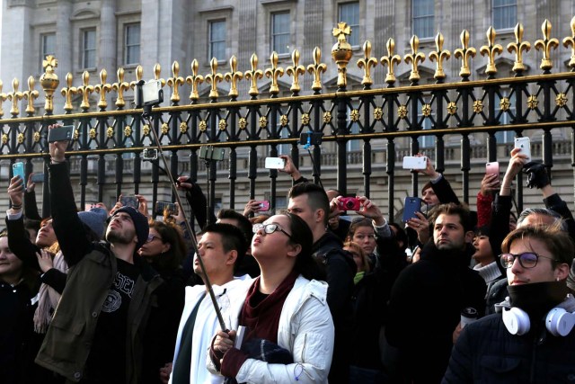 Tourists take pictures outside Buckingham Palace after Prince Harry announces his engagement to Meghan Markle, in London, Britain, November 27, 2017. REUTERS/Darrin Zammit Lupi