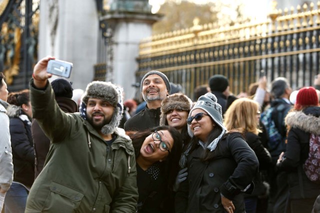 Tourists take pictures outside Buckingham Palace after Prince Harry announced his engagement to Meghan Markle, in London, Britain, November 27, 2017. REUTERS/Darrin Zammit Lupi