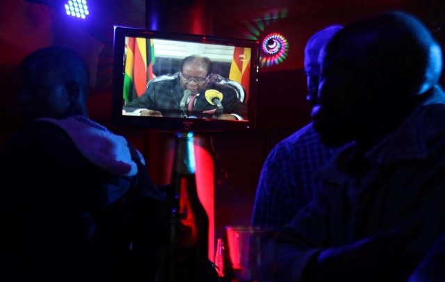 People watch as Zimbabwean President Robert Mugabe addresses the nation on television, at a bar in Harare, Zimbabwe, November 19, 2017. REUTERS/Philimon Bulawayo