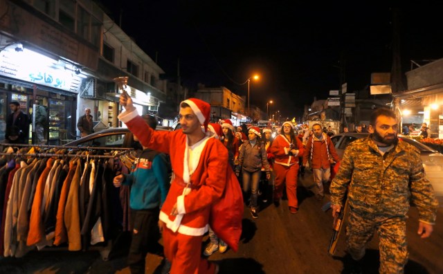 Syrians dressed in Christmas outfits roam the streets of the capital Damascus as they celebrate Christmas eve on December 24, 2017, while being escorted by Syrian forces. / AFP PHOTO / LOUAI BESHARA