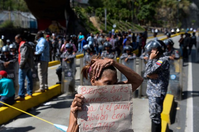 Venezuelans take part in a protest against the shortage of food in Caracas on December 28, 2017. As Venezuelans protest in Caracas demanding the government's prommised pork -the main dish of the Christmas and New Year's dinner-, President Nicolas Maduro attributes the shortage to international sabotage. / AFP PHOTO / FEDERICO PARRA