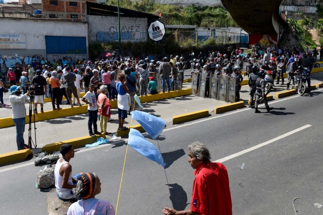 Venezuelans take part in a protest against the shortage of food in Caracas on December 28, 2017. As Venezuelans protest in Caracas demanding the government's prommised pork -the main dish of the Christmas and New Year's dinner-, President Nicolas Maduro attributes the shortage to international sabotage. / AFP PHOTO / FEDERICO PARRA