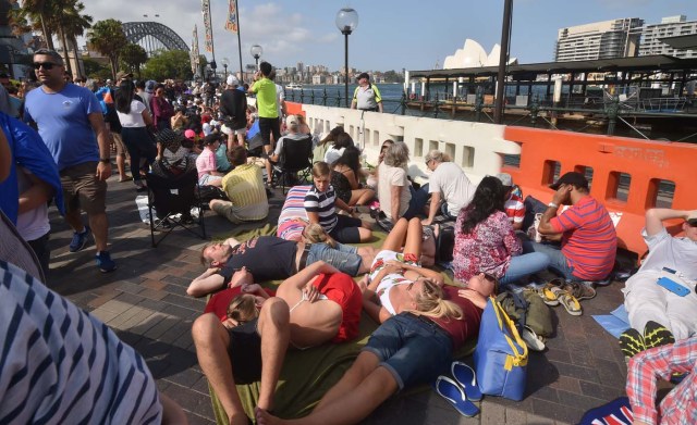 Crowds gather at Circular Quay ahead of the New Year's Eve fireworks display in Sydney on December 31, 2017. Australia's largest city Sydney will welcome 2018 with a rainbow-themed fireworks spectacular marking new same-sex marriage rights, with heavy security for festivities that kick off a wave of celebrations around the world. / AFP PHOTO / PETER PARKS