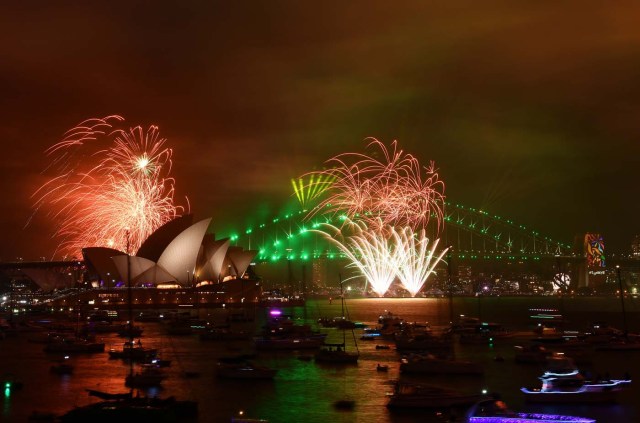 The "family fireworks", displayed three hours before midnight every year ahead of the main show at midnight, fill the sky over the Opera House and Harbour Bridge in Sydney on New Year's Eve on December 31, 2017. / AFP PHOTO / Saeed KHAN