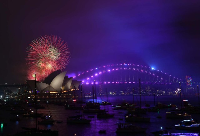 The "family fireworks", displayed three hours before midnight every year ahead of the main show at midnight, fill the sky over the Opera House and Harbour Bridge in Sydney on New Year's Eve on December 31, 2017. / AFP PHOTO / SAEED KHAN