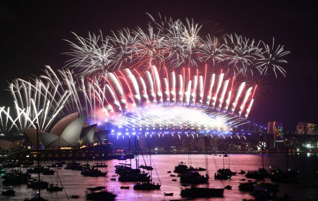 Fireworks light the sky over the Opera House and Harbour Bridge during New Year's Eve celebrations in Sydney early on January 1, 2018. / AFP PHOTO / SAEED KHAN