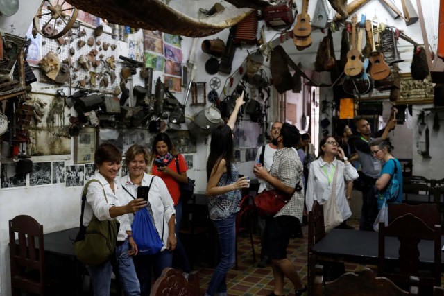 Attendees of a walking tour of 'Caracas in 365' look around inside 'Bar El Torero' (The Bullfighter) at Catia neighborhood in Caracas, Venezuela November 18, 2017. Picture taken November 18, 2017. REUTERS/Marco Bello