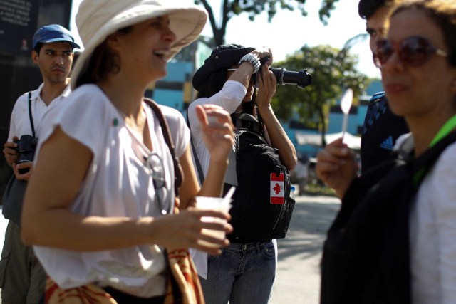 A woman takes photos during a walking tour of 'Caracas in 365' at Catia neighborhood in Caracas, Venezuela November 18, 2017. Picture taken November 18, 2017. REUTERS/Marco Bello