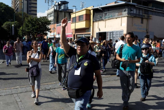 A coordinator of 'Caracas in 365' gedstures to attendees during a walking tour at Catia neighborhood in Caracas, Venezuela November 18, 2017. Picture taken November 18, 2017. REUTERS/Marco Bello