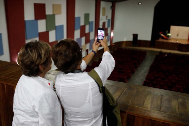 Women take selfies inside the Catia Theater during a walking tour of 'Caracas in 365' at Catia neighborhood in Caracas, Venezuela November 18, 2017. Picture taken November 18, 2017. REUTERS/Marco Bello