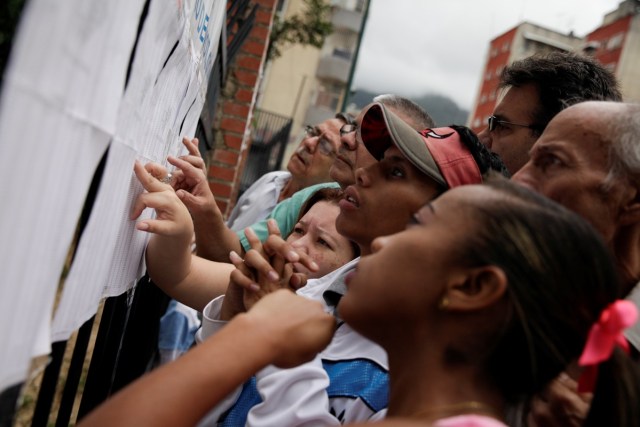 People check a list at a polling station during a nationwide election for new mayors, in Caracas, Venezuela December 10, 2017. REUTERS/Fabiola Ferrero