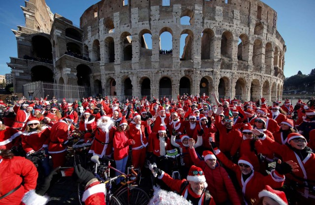 More than a hundred cyclists dressed as Santa Claus meet at the Colosseum in Rome, Italy December 17, 2017. REUTERS/Tony Gentile