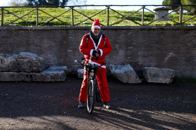 A man poses as more than a hundred cyclists dressed as Santa Claus meet at the Colosseum in Rome, Italy December 17, 2017. REUTERS/Tony Gentile