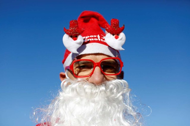 A man poses as more than a hundred cyclists dressed as Santa Claus meet at the Colosseum in Rome, Italy December 17, 2017. REUTERS/Tony Gentile