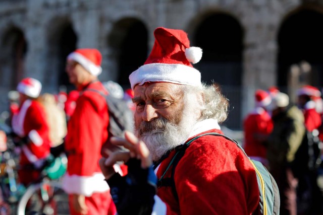 A man poses as more than a hundred cyclists dressed as Santa Claus meet at the Colosseum in Rome, Italy December 17, 2017. REUTERS/Tony Gentile