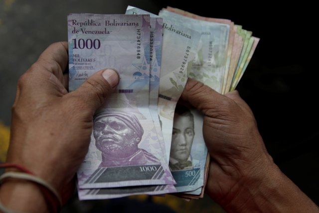 Un trabajador cuenta bolívares venezolanos en una gasolinera de la petrolera estatal venezolana PDVSA en Caracas, Venezuela, el 1 de diciembre de 2017. REUTERS / Marco Bello