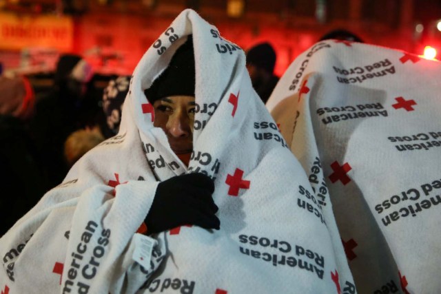 Evacuees wear blankets as they stand after a fire at an apartment building in Bronx, New York, U.S., December 28, 2017. REUTERS/Amr Alfiky