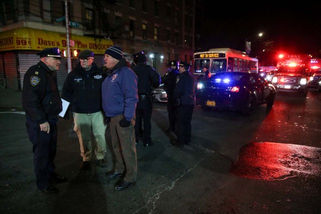 New York Police Department (NYPD) officers stand guard during an evacuation following a fire at an apartment building in Bronx, New York, U.S., December 28, 2017. REUTERS/Amr Alfiky