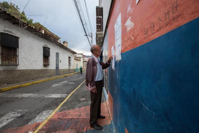 Un hombre busca su puesto de votación para las elecciones municipales hoy, domingo 10 de diciembre de 2017, en Caracas (Venezuela). Los centros de votación comenzaron a abrir hoy en Venezuela desde las 06.00 hora local (10.00 GMT) para la elección de 335 alcaldes y del gobernador del estado Zulia (oeste), una contienda en la que el grueso de la oposición no participará. EFE/NATHALIE SAYAGO