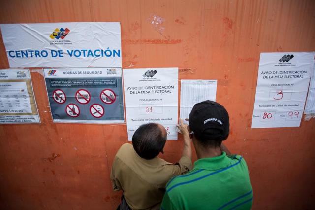 Ciudadanos buscan su puesto de votación en las elecciones municipales hoy, domingo 10 de diciembre de 2017, en Caracas (Venezuela). Los centros de votación comenzaron a abrir hoy en Venezuela desde las 06.00 hora local (10.00 GMT) para la elección de 335 alcaldes y del gobernador del estado Zulia (oeste), una contienda en la que el grueso de la oposición no participará. EFE/NATHALIE SAYAGO