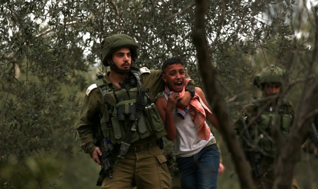 NAB01. NABLUS (GAZA Y CISJORDANIA), 20/12/2017.- Un niño palestino llora mientras es arrestado por soldados israelíes durante unas propuestas en el punto de control de Huwwara cerca de Nablus, Palestina, hoy, 20 de diciembre de 2017. Las protestas se han incrementado después de la decisión del presidente de Estados Unidos, Donald Trump, del pasado 6 de diciembre, de reconocer Jersualén como capital israelí y de mover la embajada estadounidense de Tel Avív a Jerusalén. EFE/ Alaa Badarneh