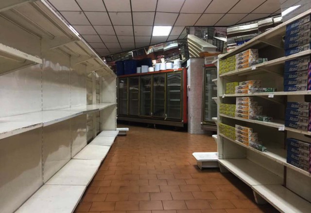 View of partially empty supermarket shelves in Caracas on January 6, 2018. Venezuela's government forced more that 200 establishments to lower prices in the middle of a hyperinflationary spiral. / AFP PHOTO / JUAN BARRETO