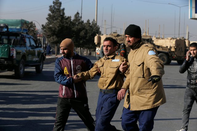 A wounded security guard receives help after being rescued from Kabul's Intercontinental Hotel during an attack by gunmen in Kabul, Afghanistan January 21, 2018.REUTERS/Omar Sobhani