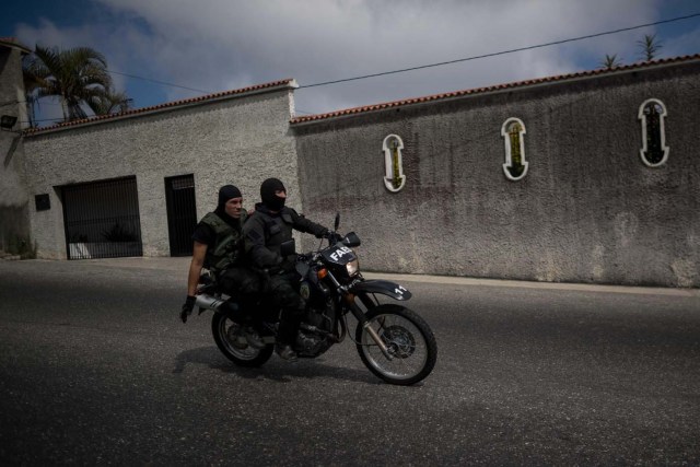 CAR06. CARACAS (VENEZUELA), 15/01/2018.- Agentes de las Fuerzas Armadas Bolivarianas cruzan en una motocicleta hacia el lugar donde se realiza una operación contra el grupo liderado por el policía Óscar Pérez hoy, lunes 15 de enero de 2018, en el barrio El Junquito, en Caracas (Venezuela). Las autoridades venezolanas desarticularon hoy el grupo liderado por el policía Oscar Pérez, acusado de "ataque terrorista" al Supremo, e informaron de haber "abatido" a un grupo no identificado de sus miembros y detenido a cinco. EFE/Miguel Gutiérrez