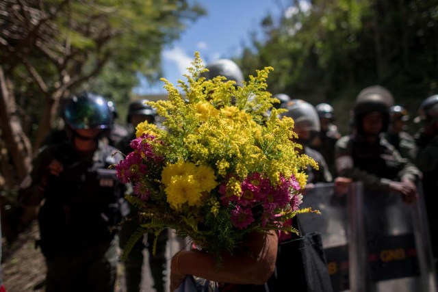 CAR010. CARACAS (VENEZUELA), 20/01/2018. Miembros de la Guardia Nacional Bolivariana (GNB) custodian una parcela del Cementerio del Este y cercan el paso a familiares de José Díaz Pimentel y a Abraham Agostini hoy, sábado 20 de enero del 2018, en Caracas (Venezuela). Dos de las seis personas abatidas junto al exinspector alzado contra el Gobierno venezolano Óscar Pérez fueron enterrados hoy en medio de denuncias de que los familiares no autorizaron el sepelio, mientras continúa la incertidumbre sobre qué se hará con el cuerpo del líder del grupo. EFE/Miguel Gutiérrez