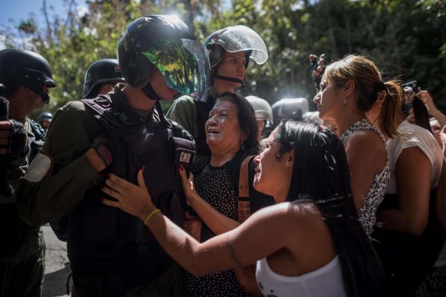 CAR012. CARACAS (VENEZUELA), 20/01/2018. Miembros de la Guardia Nacional Bolivariana (GNB) custodian una parcela del Cementerio del Este y cercan el paso a familiares de José Díaz Pimentel y a Abraham Agostini hoy, sábado 20 de enero del 2018, en Caracas (Venezuela). Dos de las seis personas abatidas junto al exinspector alzado contra el Gobierno venezolano Óscar Pérez fueron enterrados hoy en medio de denuncias de que los familiares no autorizaron el sepelio, mientras continúa la incertidumbre sobre qué se hará con el cuerpo del líder del grupo. EFE/Miguel Gutiérrez