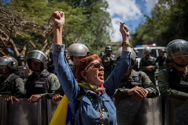 CAR017. CARACAS (VENEZUELA), 20/01/2018. Miembros de la Guardia Nacional Bolivariana (GNB) custodian una parcela del Cementerio del Este y cercan el paso a familiares de José Díaz Pimentel y a Abraham Agostini hoy, sábado 20 de enero del 2018, en Caracas (Venezuela). Dos de las seis personas abatidas junto al exinspector alzado contra el Gobierno venezolano Óscar Pérez fueron enterrados hoy en medio de denuncias de que los familiares no autorizaron el sepelio, mientras continúa la incertidumbre sobre qué se hará con el cuerpo del líder del grupo. EFE/Miguel Gutiérrez