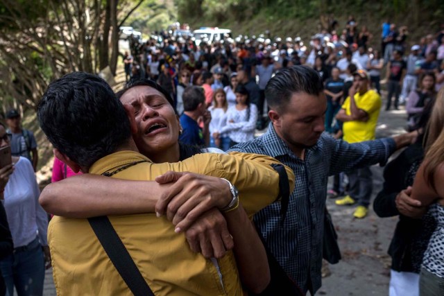 CAR024. CARACAS (VENEZUELA), 20/01/2018. Familiares de José Díaz Pimentel y Abraham Agostini lloran en la parcela donde ambos fueron enterrados hoy, sábado 20 de enero del 2018, en Caracas (Venezuela). Dos de las seis personas abatidas junto al exinspector alzado contra el Gobierno venezolano Óscar Pérez fueron enterrados hoy en medio de denuncias de que los familiares no autorizaron el sepelio, mientras continúa la incertidumbre sobre qué se hará con el cuerpo del líder del grupo. EFE/Miguel Gutiérrez