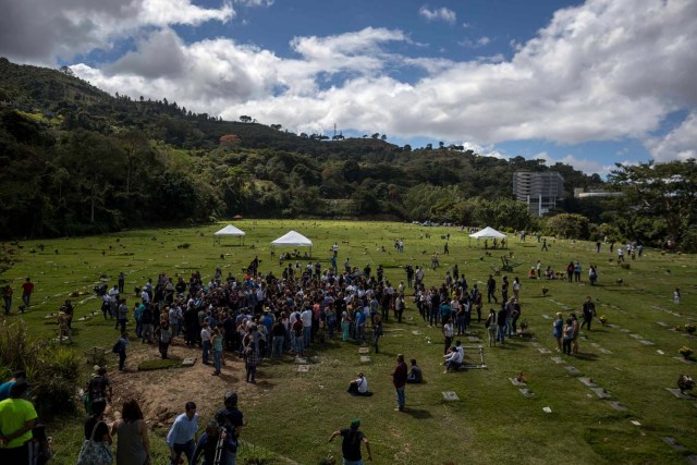 CAR032. CARACAS (VENEZUELA), 20/01/2018. Un grupo de personas acompañan a familiares de José Díaz Pimentel y Abraham Agostini en la parcela donde ambos fueron enterrados hoy, sábado 20 de enero del 2018, en Caracas (Venezuela). Dos de las seis personas abatidas junto al exinspector alzado contra el Gobierno venezolano Óscar Pérez fueron enterrados hoy en medio de denuncias de que los familiares no autorizaron el sepelio, mientras continúa la incertidumbre sobre qué se hará con el cuerpo del líder del grupo. EFE/Miguel Gutiérrez