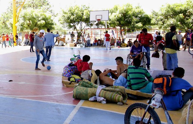 CUC05. CÚCUTA (COLOMBIA), 22/01/2018.- Un grupo de venezolanos que se tomó un polideportivo de un barrio de la ciudad de Cúcuta (Colombia) permanece dentro del recinto mientras que decenas de colombianos protestan en contra de su presencia hoy, lunes 22 de enero de 2018. Las autoridades locales dieron un plazo de dos días a los venezolanos para que desalojen este lugar. EFE/SCHNEYDER MENDOZA