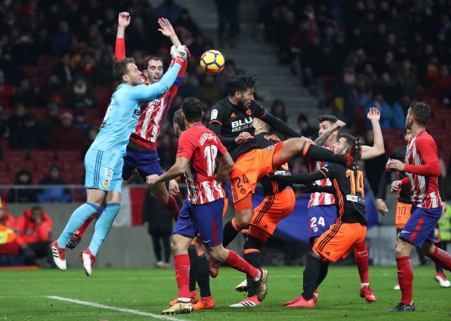 Soccer Football - La Liga Santander - Atletico Madrid vs Valencia - Wanda Metropolitano, Madrid, Spain - February 4, 2018 Atletico Madrid's Diego Godin sustains an injury in a clash with Valencia's Neto as he punches the ball clear REUTERS/Susana Vera