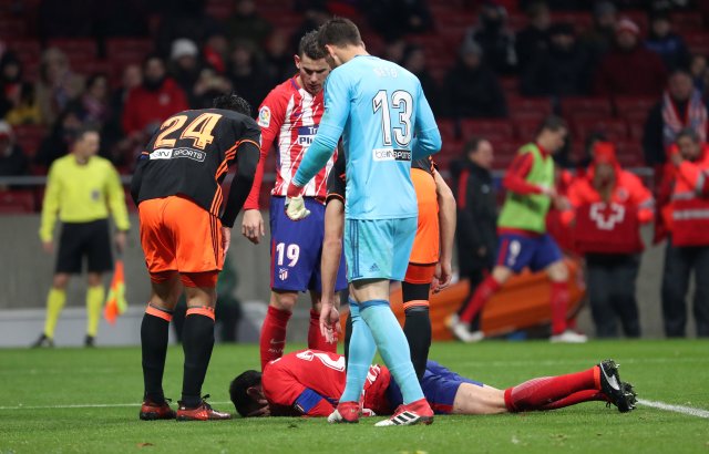 Soccer Football - La Liga Santander - Atletico Madrid vs Valencia - Wanda Metropolitano, Madrid, Spain - February 4, 2018 Atletico Madrid's Diego Godin lies on the pitch after sustaining an injury in a clash with Valencia's Neto REUTERS/Susana Vera