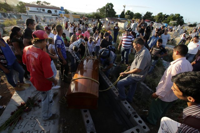 Mourners stand next to the coffin of Joel Contreras, who died during clashes between Venezuelan soldiers and illegal miners in Guasipati according to local media, during his funeral at the cemetery in Upata, Venezuela February 12, 2018. REUTERS/William Urdaneta NO RESALES. NO ARCHIVES